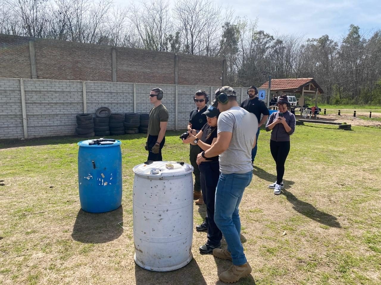 Instructor acompañando a una cursante en la práctica con pistola